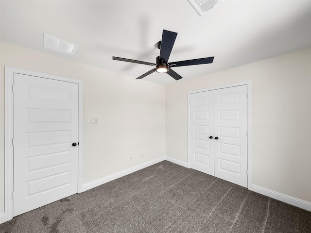 unfurnished bedroom with baseboards, visible vents, and dark carpet