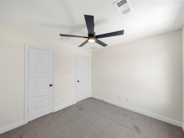 unfurnished bedroom featuring carpet floors, baseboards, visible vents, and a ceiling fan