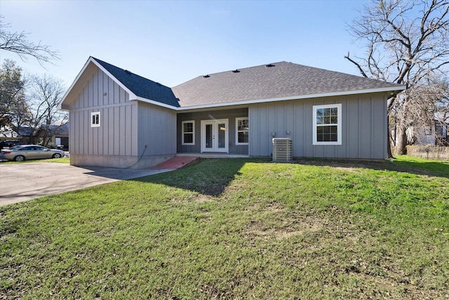 back of property with a lawn, central air condition unit, and french doors