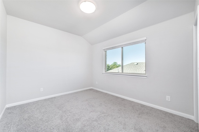 empty room with carpet flooring and lofted ceiling