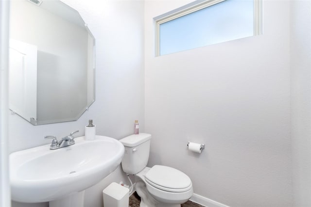 bathroom with a wealth of natural light, sink, and toilet