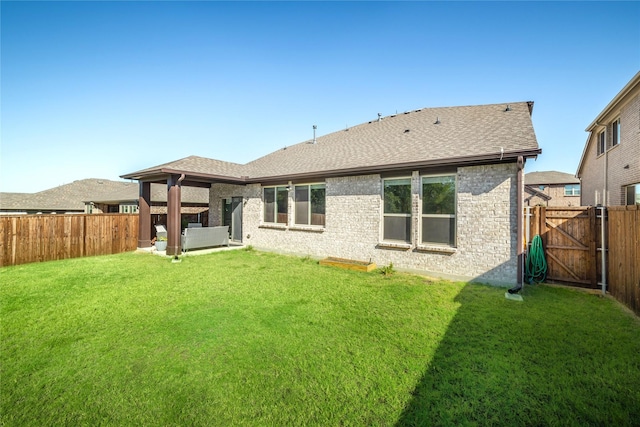 rear view of house featuring a yard