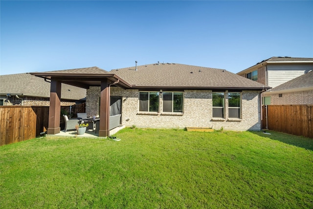 back of house featuring a lawn and a patio