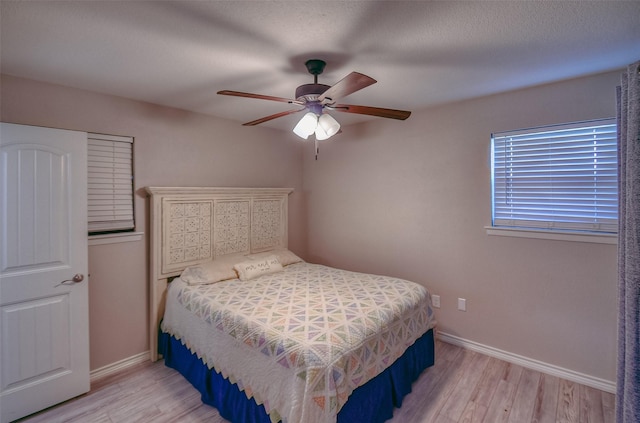 bedroom with ceiling fan, a textured ceiling, and light wood-type flooring