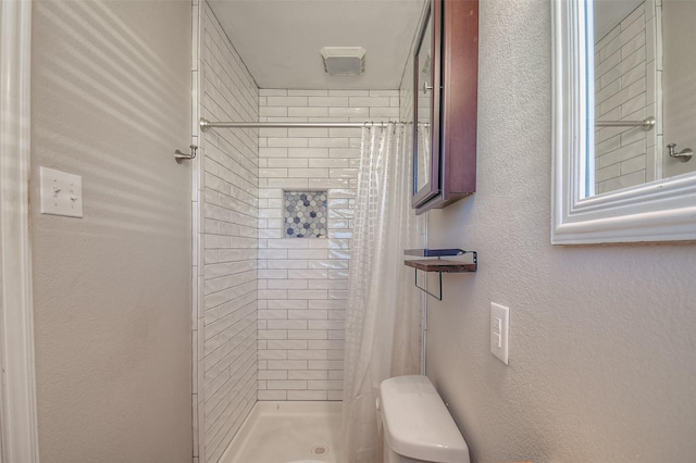 bathroom featuring toilet and walk in shower