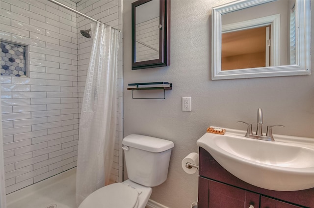 bathroom with toilet, vanity, and walk in shower