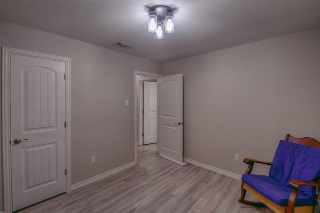 living area featuring light hardwood / wood-style floors and a textured ceiling