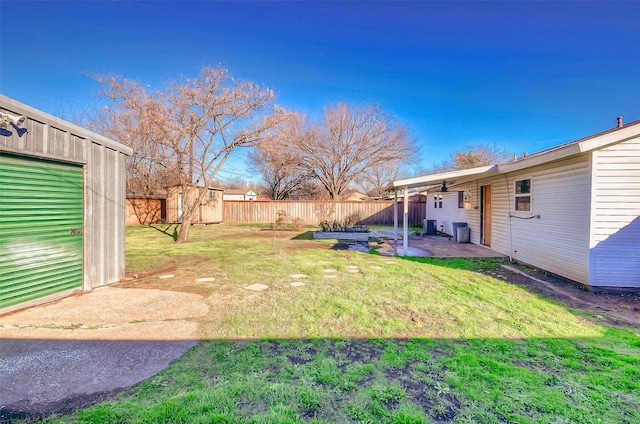 view of yard with a patio area, a storage shed, and central AC