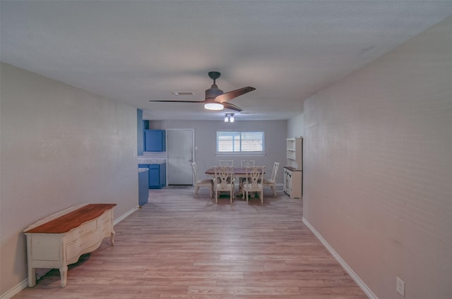 dining space with ceiling fan and light wood-type flooring