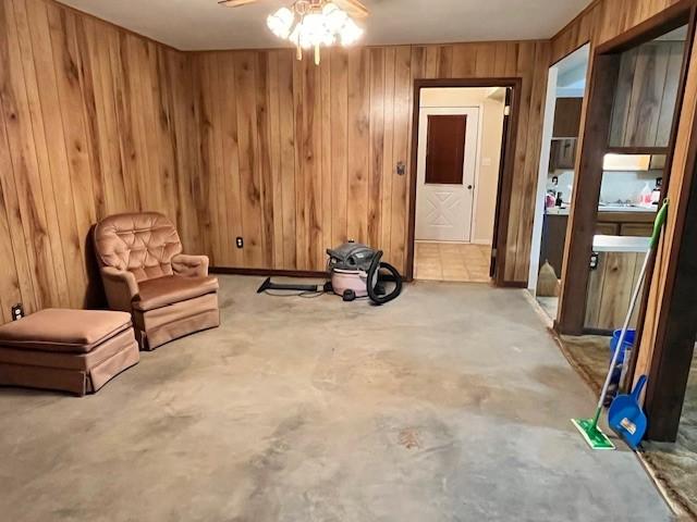 unfurnished room with ceiling fan and wooden walls