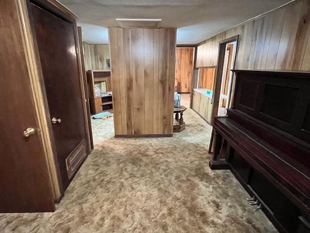 hall with wood walls and light colored carpet