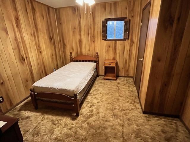 carpeted bedroom with billiards and wooden walls