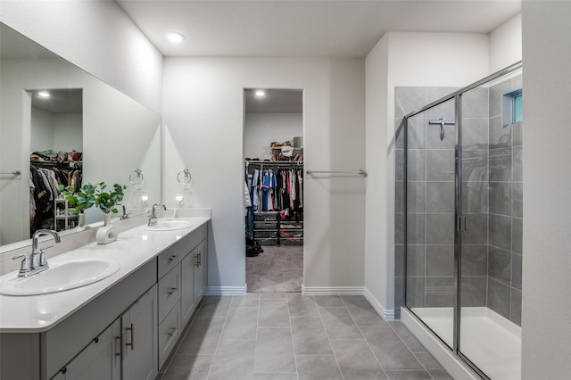 bathroom with an enclosed shower, vanity, and tile patterned flooring