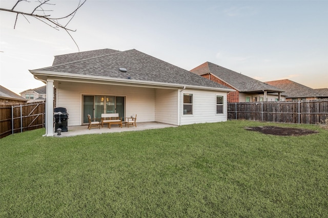 back house at dusk with a lawn, outdoor lounge area, and a patio