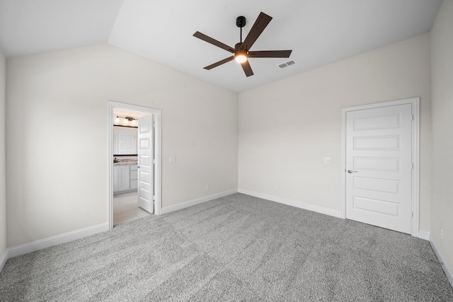 unfurnished bedroom with light carpet, ceiling fan, connected bathroom, a closet, and lofted ceiling