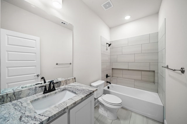 full bathroom with toilet, vanity, and tiled shower / bath