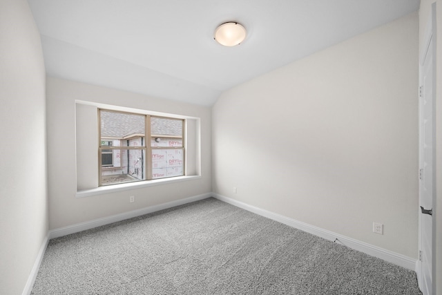 carpeted empty room featuring lofted ceiling