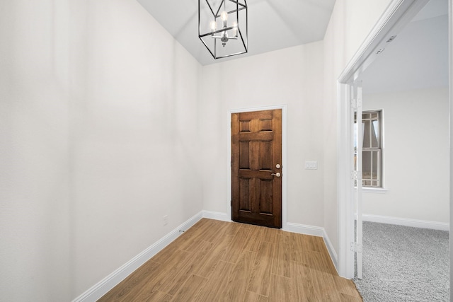 hall featuring a notable chandelier and light hardwood / wood-style flooring