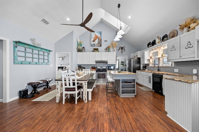 kitchen with a breakfast bar, a center island, white cabinets, sink, and appliances with stainless steel finishes