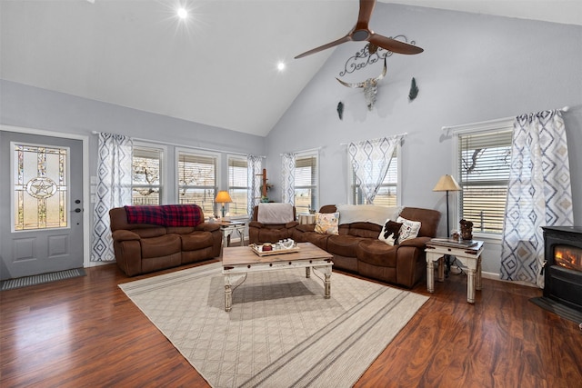 living room with high vaulted ceiling, a wood stove, dark hardwood / wood-style floors, and ceiling fan