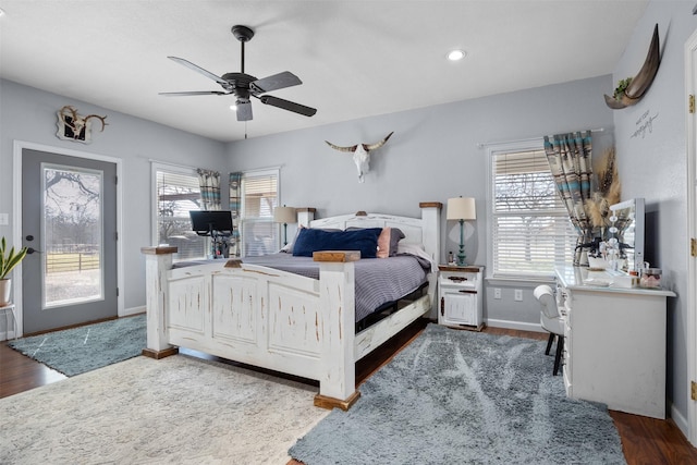 bedroom with multiple windows, dark hardwood / wood-style flooring, and ceiling fan