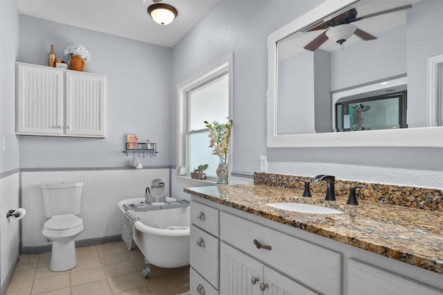 bathroom featuring ceiling fan, a washtub, tile patterned floors, toilet, and vanity