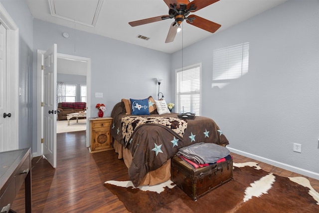 bedroom with ceiling fan, dark wood-type flooring, and multiple windows