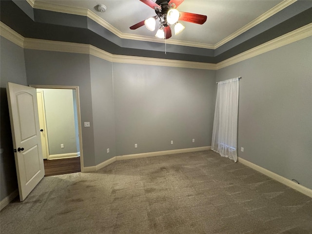 spare room featuring carpet flooring, ceiling fan, ornamental molding, and a tray ceiling