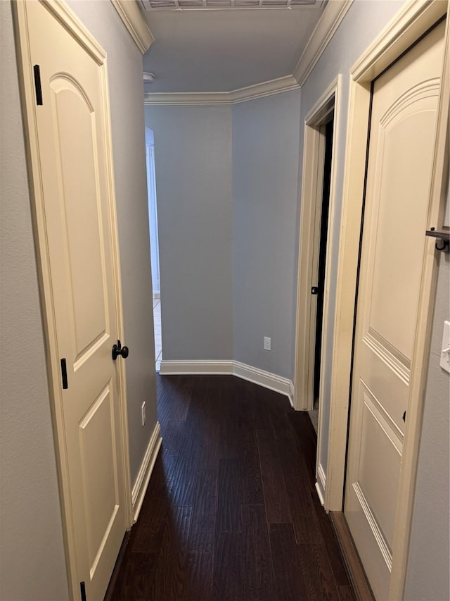 corridor with dark wood-type flooring and ornamental molding