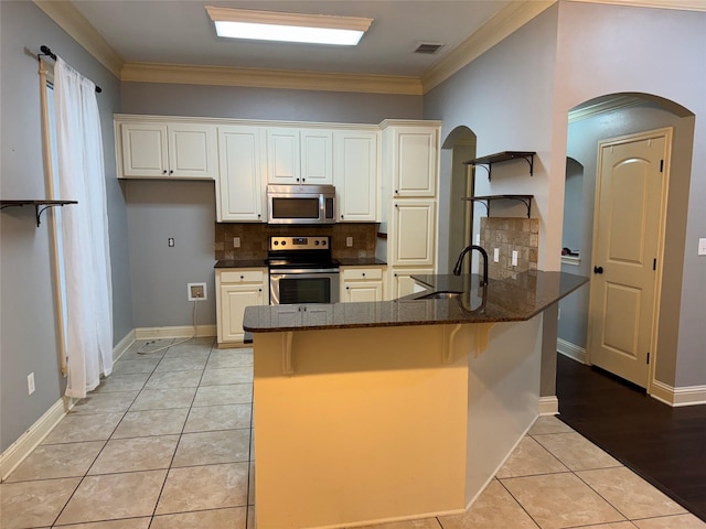 kitchen featuring crown molding, sink, light tile patterned floors, appliances with stainless steel finishes, and kitchen peninsula