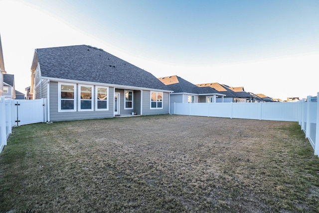 back house at dusk with a yard