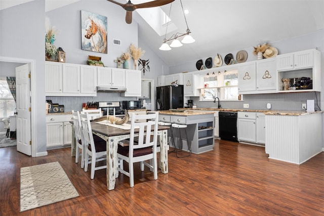kitchen with tasteful backsplash, black appliances, high vaulted ceiling, white cabinets, and a kitchen island