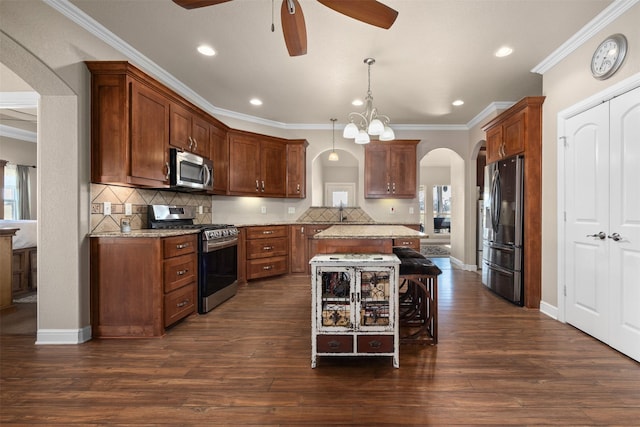 kitchen featuring light stone counters, a breakfast bar, hanging light fixtures, and appliances with stainless steel finishes