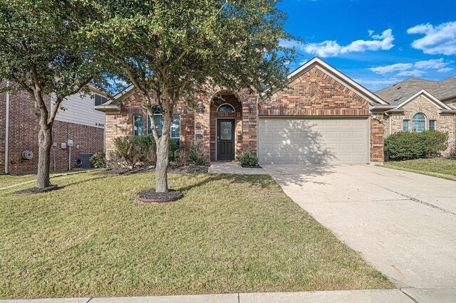 view of front of property featuring a front yard, central AC, and a garage