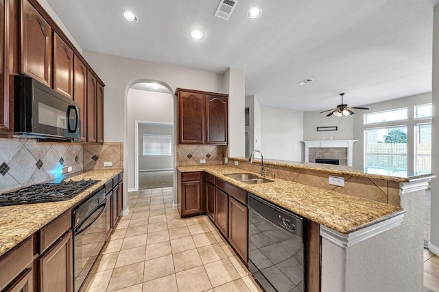 kitchen with visible vents, ceiling fan, a peninsula, black appliances, and a sink