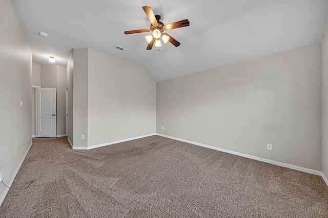 spare room with carpet floors, lofted ceiling, visible vents, ceiling fan, and baseboards