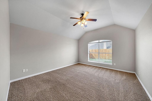 spare room featuring lofted ceiling, ceiling fan, carpet, and baseboards