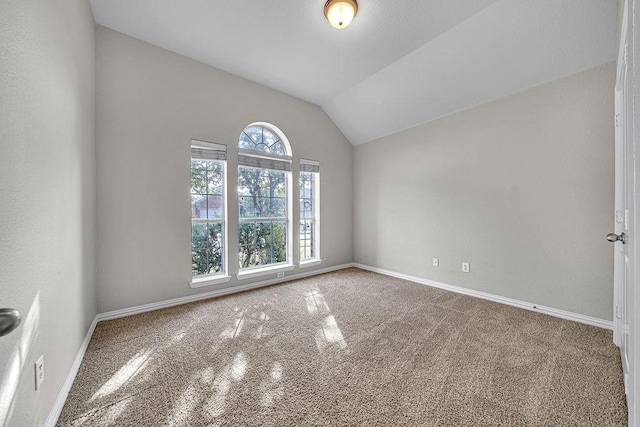 unfurnished room featuring vaulted ceiling and baseboards