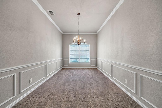 spare room with a decorative wall, carpet flooring, visible vents, and a notable chandelier