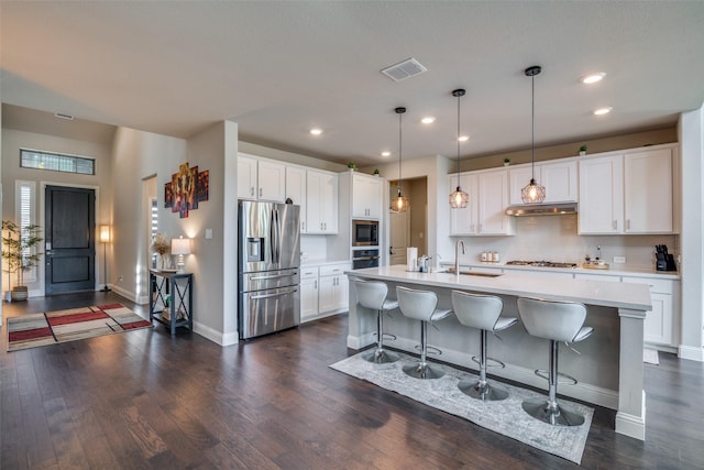 kitchen featuring white cabinetry, sink, an island with sink, pendant lighting, and appliances with stainless steel finishes