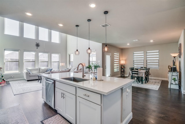 kitchen featuring sink, stainless steel dishwasher, pendant lighting, a kitchen island with sink, and white cabinets