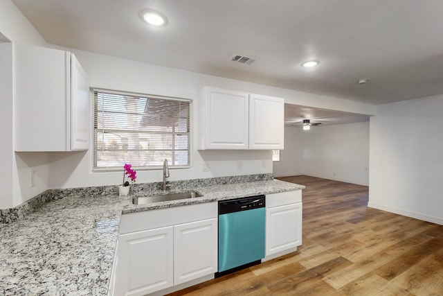 kitchen featuring visible vents, dishwasher, light stone counters, white cabinetry, and a sink