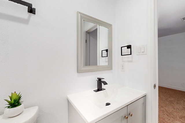 bathroom with visible vents, toilet, vanity, and baseboards