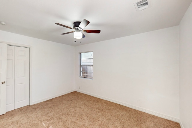 unfurnished bedroom with a closet, visible vents, a ceiling fan, light carpet, and baseboards