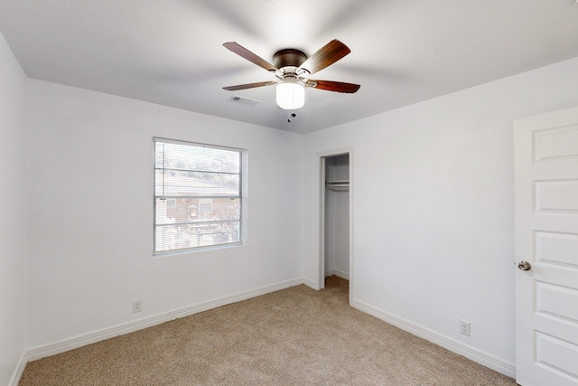 unfurnished bedroom featuring light carpet, ceiling fan, a closet, and baseboards