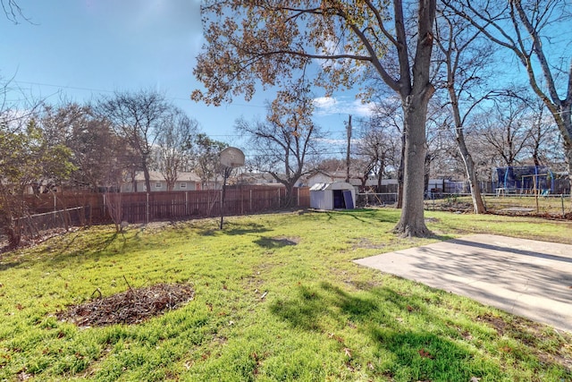 view of yard featuring a fenced backyard, a storage unit, a patio, and an outbuilding