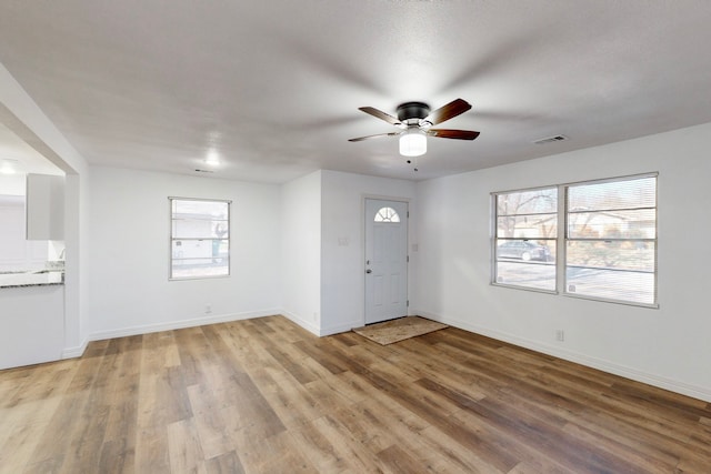 entrance foyer with baseboards, visible vents, ceiling fan, and light wood finished floors