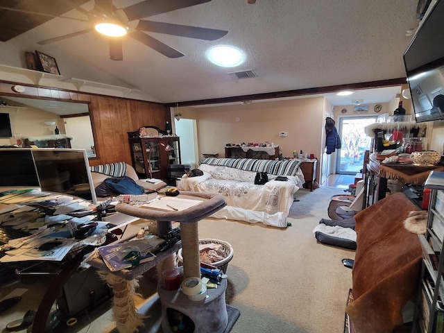 bedroom featuring wood walls, vaulted ceiling, carpet flooring, ceiling fan, and a textured ceiling