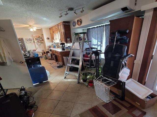 kitchen featuring light tile patterned floors, a textured ceiling, a wall mounted AC, and ceiling fan