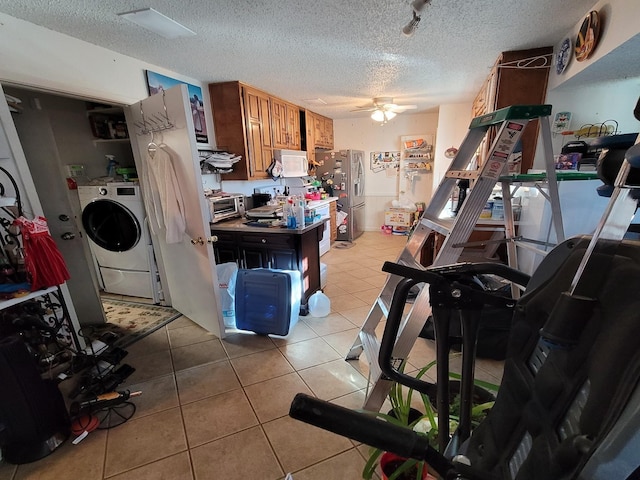 kitchen with ceiling fan, stainless steel refrigerator with ice dispenser, washer / clothes dryer, a textured ceiling, and light tile patterned floors